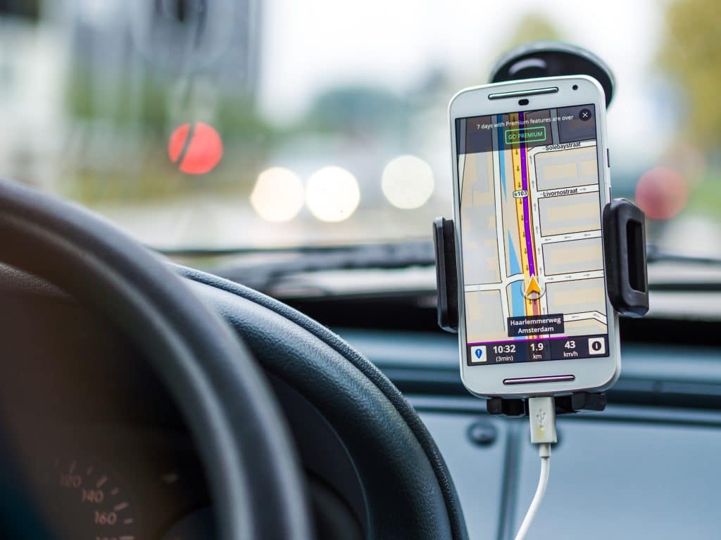 Na imagem, celular no carro com aplicativo de motorista aberto