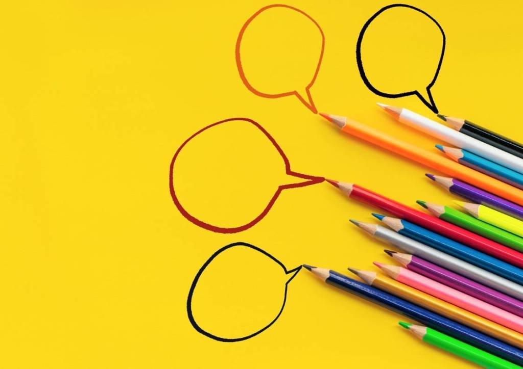 lápis de cor e balões redondos na diagonal sobre fundo amarelo
