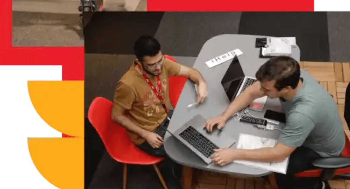 Funcionário do iFood andando de patinete em escritório, ao lado de colegas trabalhando em laptops.