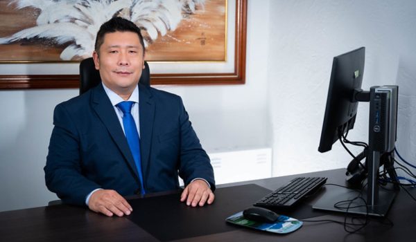 Homem oriental moreno de terno na Câmara Municipal de Curitiba.