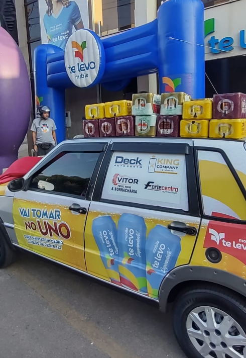 Carro de promoção "Vai Tomar no Uno" do aplicativo de mobilidade Te Levo, carregado com latas de cerveja, durante evento em Araxá (MG).