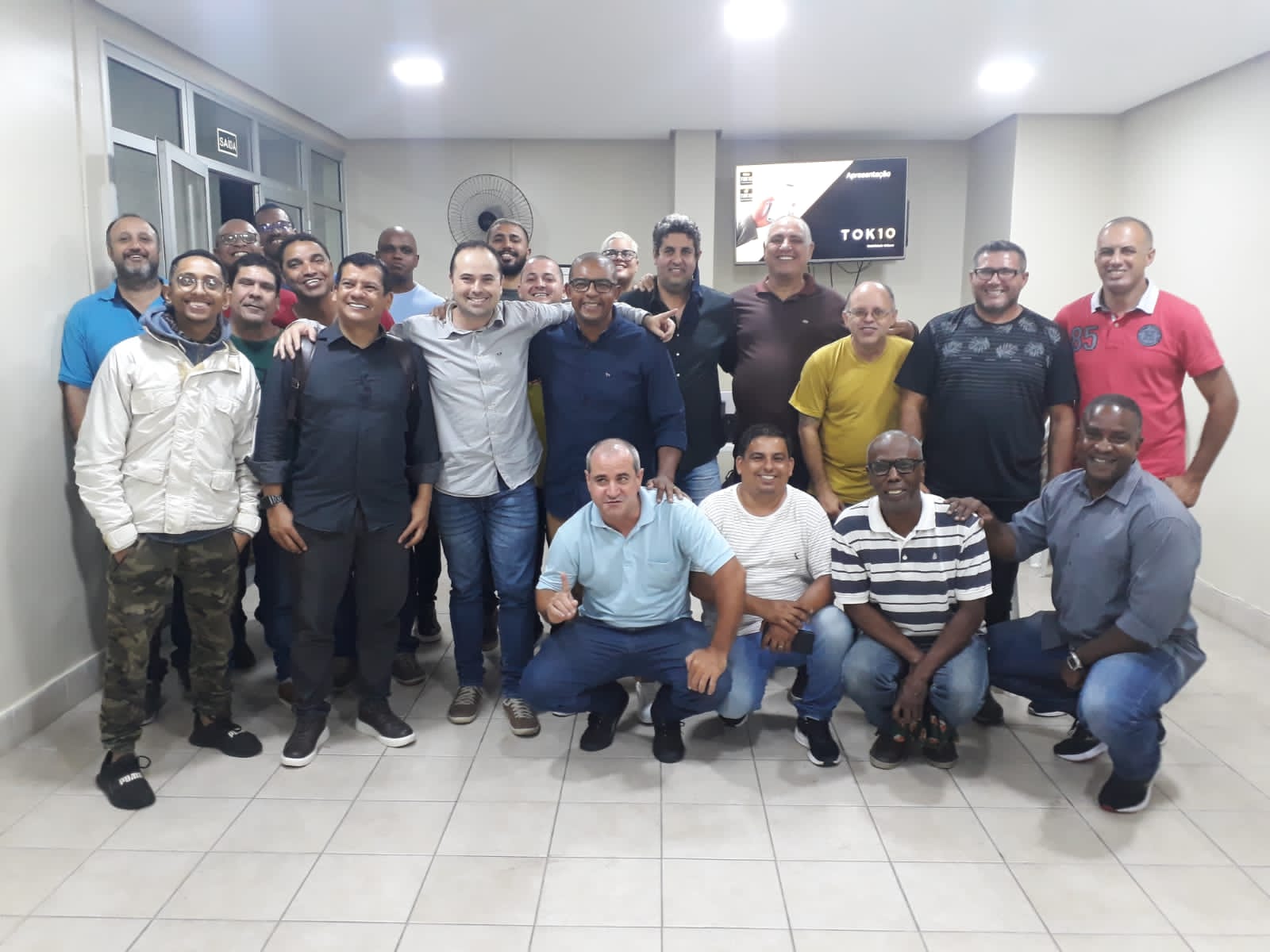 "Grupo de motoristas reunidos em um evento sobre transporte por aplicativos."