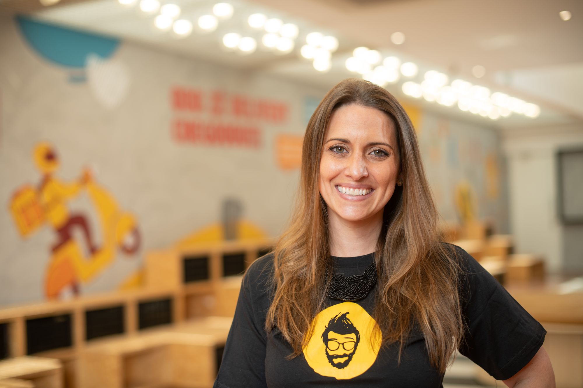 Thais Azevedo, CMO do Zé Delivery, sorrindo em um ambiente de trabalho.