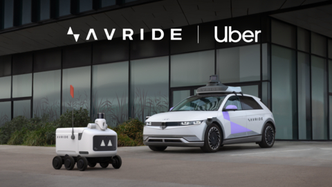 A imagem destaca um veículo autônomo da Avride ao lado de um robô de entrega da Uber, ambos estacionados em frente a um edifício comercial moderno. Esta parceria entre a Avride e a Uber visa transformar a mobilidade urbana e os serviços de entrega com o uso de tecnologia avançada de direção autônoma. O design futurista dos veículos reforça o compromisso das empresas com soluções inovadoras e eficientes para o transporte e logística do futuro, proporcionando maior eficiência e sustentabilidade.