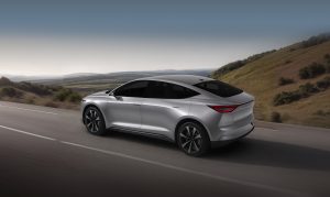 Carro híbrido Lecar 459 Híbrido dirigindo em estrada com colinas ao fundo.