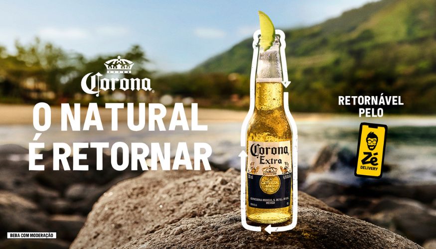 Garrafa de cerveja Corona Extra com uma fatia de limão, promovendo a campanha "O natural é retornar" em parceria com o Zé Delivery, com foco em garrafas retornáveis.
