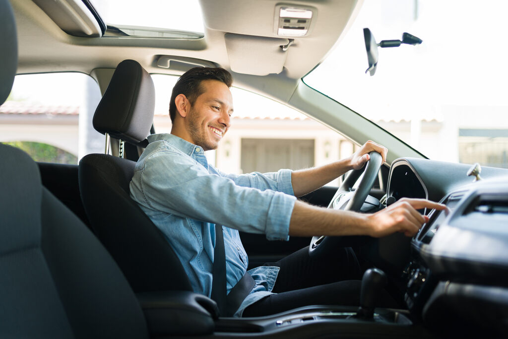 homem dentro do seu carro olhando sua câmera no carro