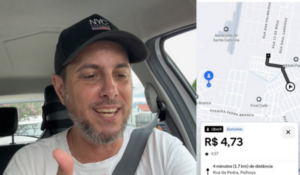 Homem dentro de um carro, usando boné preto e camiseta branca, falando com expressão animada. Ao lado, aparece a tela do aplicativo Uber mostrando uma corrida de R$ 4,73 para um trajeto de 1,7 km na cidade de Palhoça, Santa Catarina.