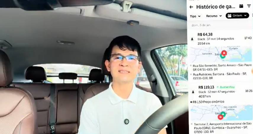 Motorista de aplicativo sentado dentro de um carro com tela do aplicativo Uber exibindo histórico de ganhos no lado direito.