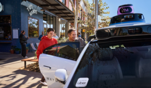 Dois passageiros entrando em um veículo autônomo da Waymo, operado pela Uber, em frente a um café em Austin, Texas.