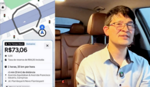 Homem asiático de óculos e camisa clara sentado no banco do motorista de um carro, ao lado de uma tela com print de corrida no aplicativo da Uber mostrando o valor de R$73,06 pelo tempo, em Campinas.