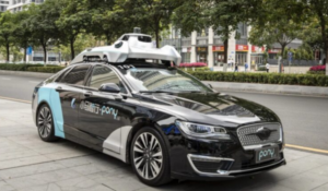 Carro autônomo da empresa Pony.ai estacionado na calçada de uma avenida urbana arborizada, equipado com sensores e câmeras no teto.