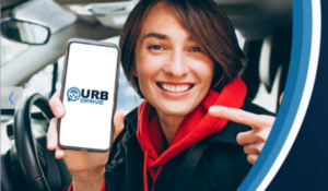 Mulher sorridente dentro de um carro segurando um smartphone com a tela exibindo o logo do app URB Drive.