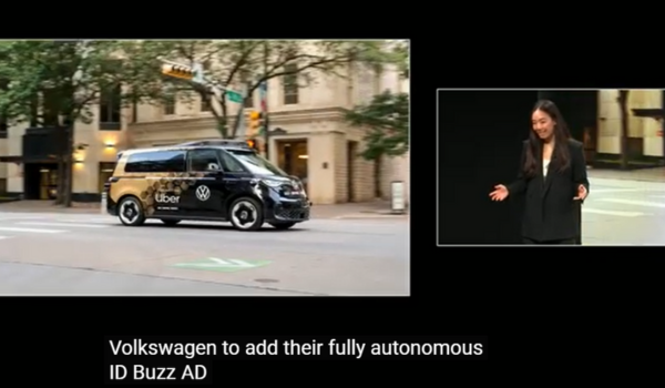 Van autônoma ID Buzz AD da Volkswagen com logotipo da Uber circulando em rua urbana; mulher apresentando a novidade em palco.