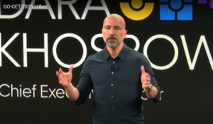 Dara Khosrowshahi, CEO da Uber, falando no evento GO-GET 2025, com o logotipo da Uber ao fundo.
