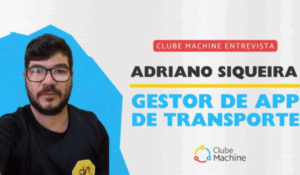 Homem de óculos com barba curta e camiseta preta com logo "dn" aparece ao lado de um banner escrito "Clube Machine Entrevista: Adriano Siqueira, Gestor de App de Transporte", com o logo do Clube Machine ao fundo.