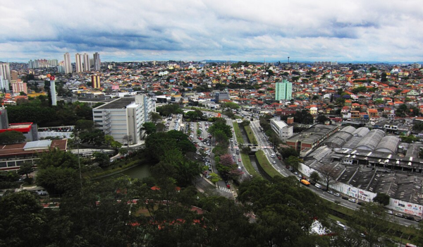 "Vista aérea de Osasco com ruas movimentadas, prédios comerciais e residenciais, além do antigo terminal de ônibus ao lado da linha férrea."