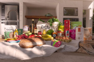 Mesa com muitos alimentos frescos, incluindo um com a logo da Trela.