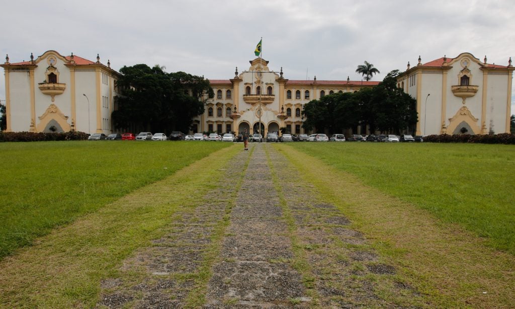Fachada principal da Universidade Federal Rural do Rio de Janeiro com gramado e caminho de pedra ao centro