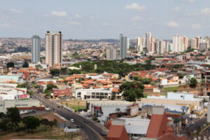 Vista urbana com prédios altos ao fundo e casas térreas em primeiro plano, em uma cidade de médio porte.