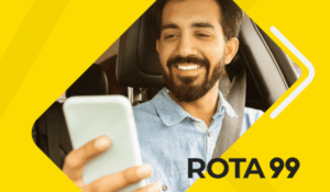 Homem sorridente dentro de um carro, usando cinto de segurança, olha para o celular. Fundo amarelo com a inscrição "ROTA 99".