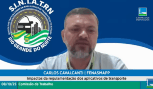 Homem fala por videoconferência durante audiência pública da Câmara dos Deputados, com fundo azul exibindo o logotipo do sindicato SINIATRN do Rio Grande do Norte.