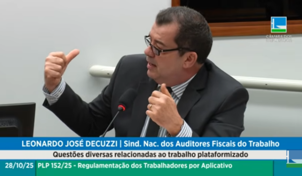 Homem de óculos fala ao microfone durante audiência pública sobre regulamentação de trabalhadores por aplicativo, gesticulando com as mãos enquanto explica um ponto.