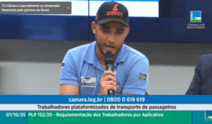 Homem com boné preto e camisa azul fala ao microfone durante audiência pública na Câmara dos Deputados.