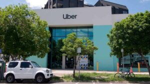 Prédio com logo da Uber e carro na frente.