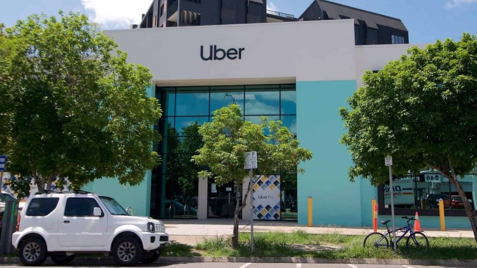Prédio com logo da Uber e carro na frente.