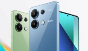 Três smartphones Redmi nas cores verde e azul, exibindo o conjunto de câmeras traseiras e a tela frontal em um fundo claro.