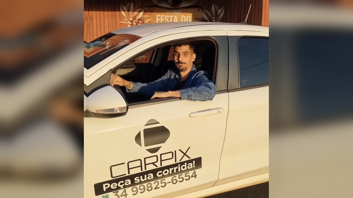 Homem sentado ao volante de um carro branco com o nome Carpix visível na porta.