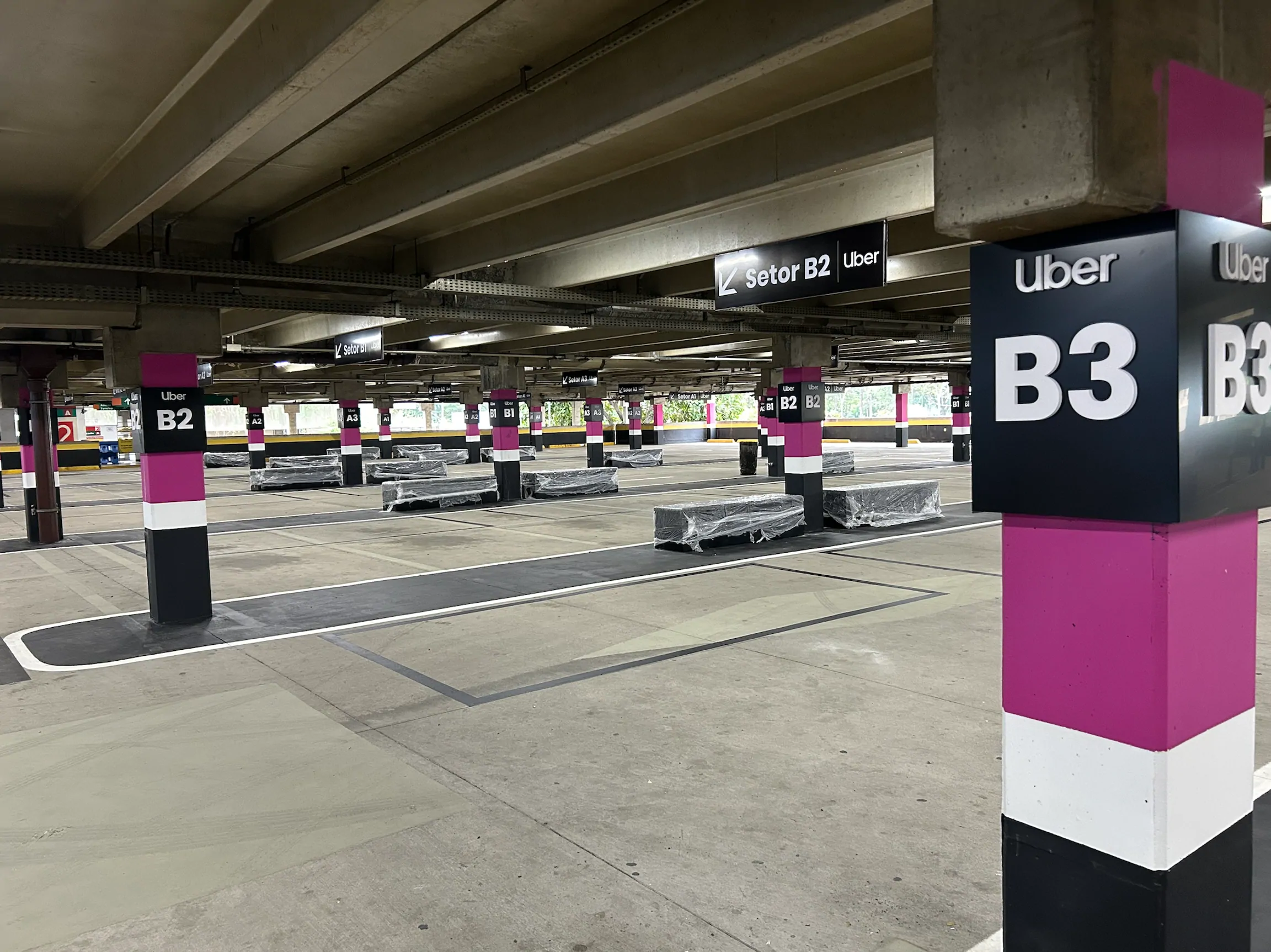 Espaço Uber no estacionamento do Terminal Rodoviário Tietê, com áreas de embarque identificadas por setores e sinalização da plataforma.