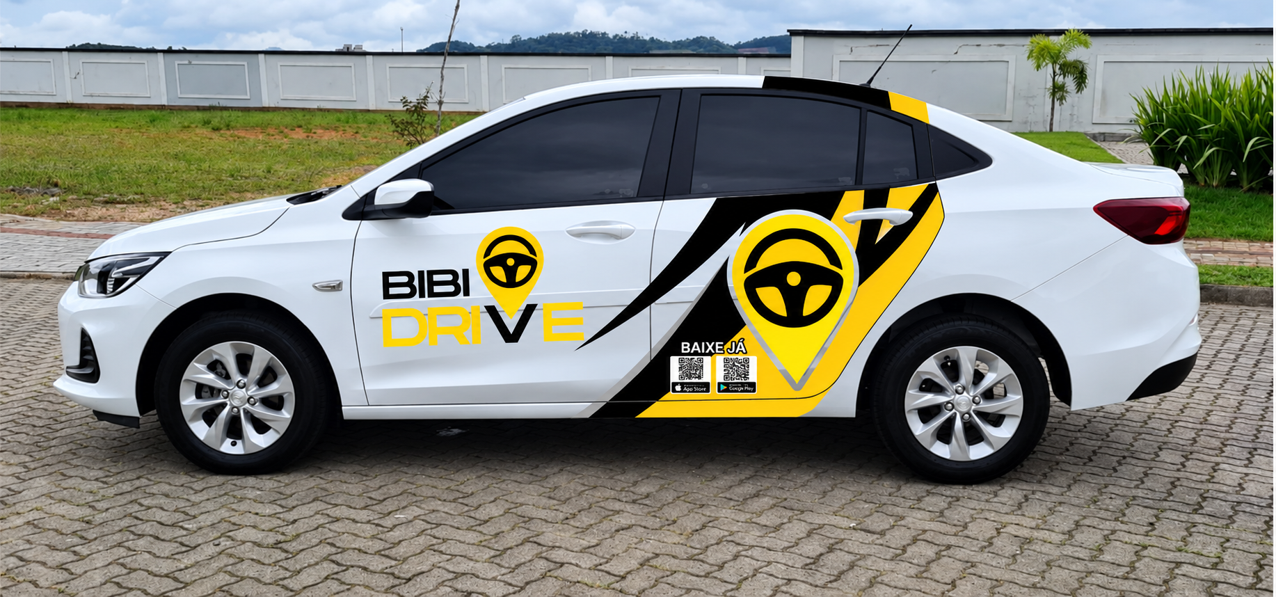Carro branco com identificação visual preta e amarela da Bibi Drive, estacionado em área pavimentada.